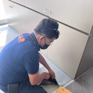 ช่างกำลังติดตั้งพรมแผ่นในห้องสำนักงานด้วยความปราณีต